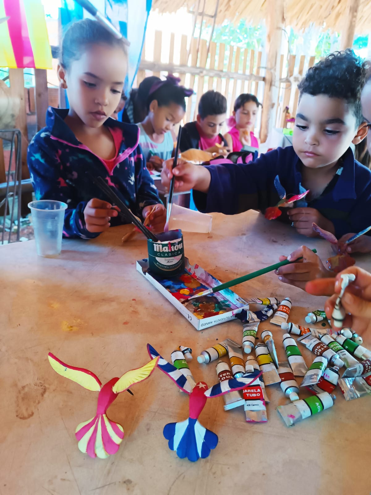 Nens pinten colibrís de fusta Nens pinten colibrís de fusta